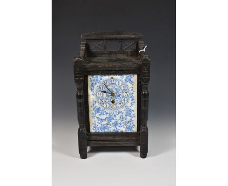 A wood and tile mantel clock with a blue and white ceramic dial decorated with blossom and butterflies. 