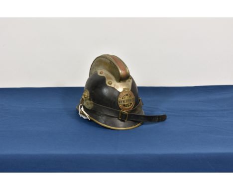 A vintage German Fire helmet the badge 'Freiwillige Feuerwehr Wienerherberg', the helmet with lion masks to the side.
