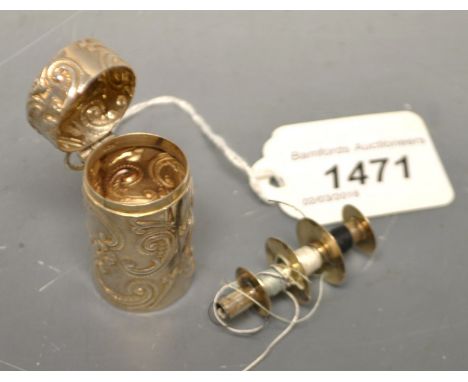 A silver bobbin case containing silver bobbin
