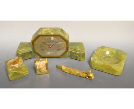 An Art Deco Elliot onyx mantel clock, faults; an onyx cigar cutter, ashtray, table lighter, etc. (5)