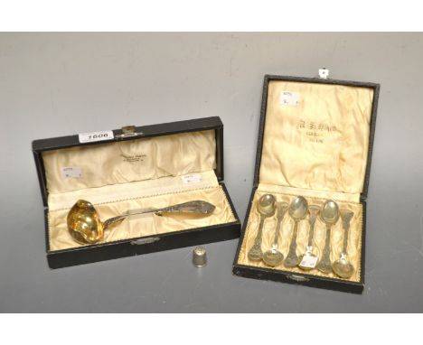Early 20th century white metal teaspoons, cased; a conforming toddy ladle; silver thimble (3)