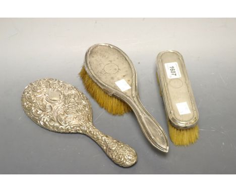 A Victorian silver backed hand mirror; another similar brush set (3)