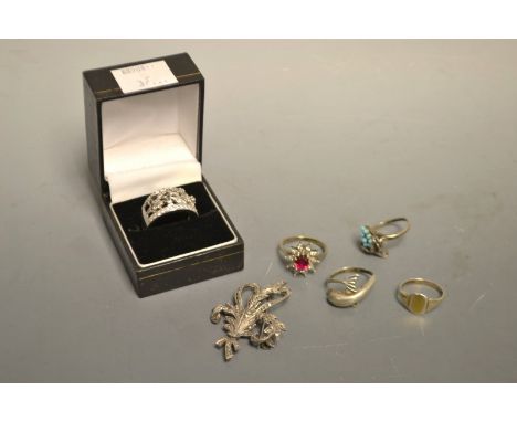 An ornate pierced silver ring; a marcasite brooch; four other rings