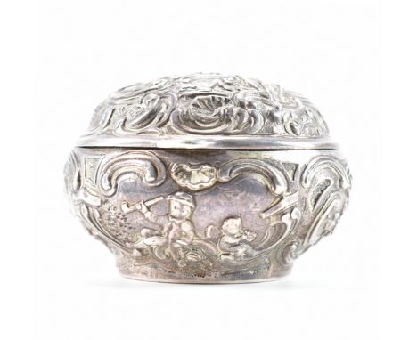 A 19th Century Victorian hallmarked silver box. The box of round form having repousse scrolled detailing featuring a courting