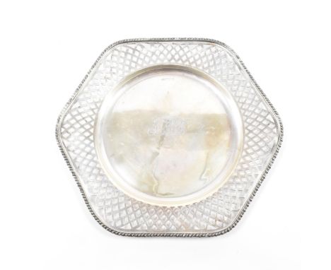 A hallmarked silver plate. The plate in a scalloped edge form having a moulded repeating pattern to the rim &amp; further pie