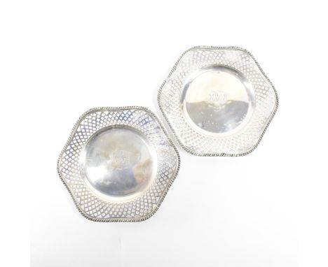 A pair of hallmarked silver plates. The plates in a scalloped edge form having a moulded repeating pattern to the rim &amp; f
