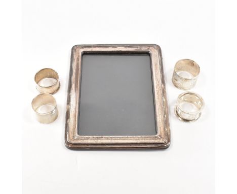 A silver and wood picture frame together with an assortment of four silver napkin rings. The Picture frame having a wooden ba