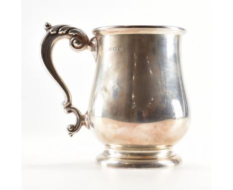 A George VI hallmarked sterling silver tankard. The tankard having a pedestal base and scrolled handle with an acanthus leaf 