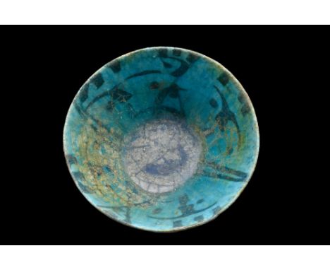 Mesopotamia, Ca. AD 800-900.A pottery bowl of deep form rising from a wide ring foot. A lovely frill-like decoration runs alo