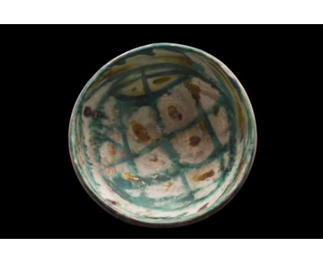 Persia, Ca. 10th century AD.A pottery bowl of a hemispherical form on a short unglazed foot. The interior is decorated with s