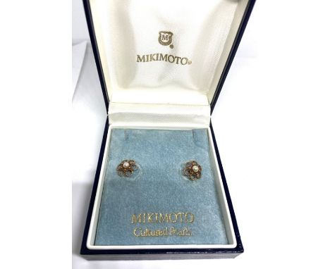 A pair of Mikimoto cultured pearl and gold ear studs, the pearls within loop flower heads, back marked indistinctly, probably