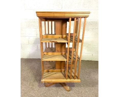 A vintage rotating bookstand, 20th century, of typical square form, with slatted supports and set on a rotational base