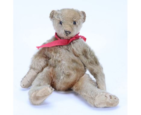 A small Steiff mohair Teddy bear, German circa 1909, the light brown straw stuffed bear with black boot button eyes, stitched