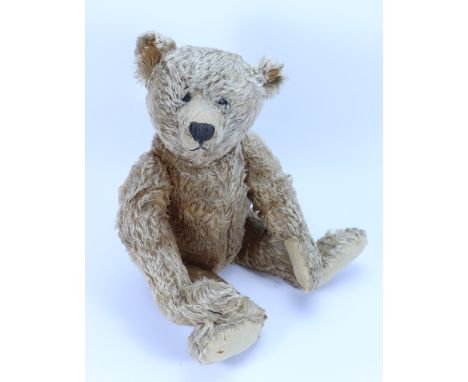 A good large Steiff light brown mohair Teddy bear, German circa 1909, the straw filled bear with black boot button eyes, poin