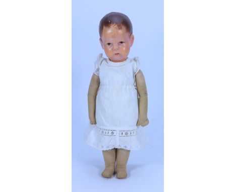 A Kathe Kruse cloth Doll, German circa 1930, the moulded synthetic head with painted features, short brown hair with wisps to