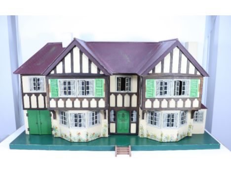 A good example of a Tri-ang No.93 large Dolls House in Tudor style, English 1930s, the painted wooden house on a green base, 