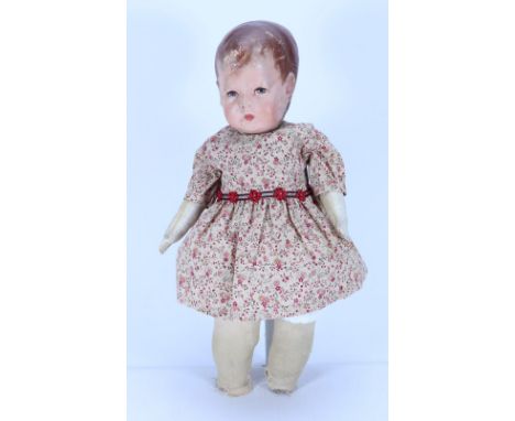 A Kathe Kruse cloth Doll I, German circa 1910, the moulded muslin head with oil painted features, short brown hair with wisps