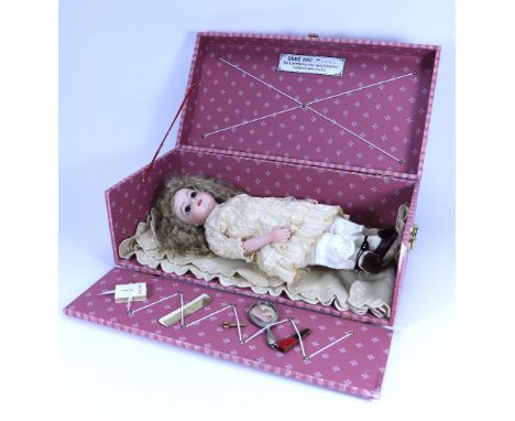 A reproduction Bru Jne bisque shoulder head doll I presentation box, with fixed brown glass eyes, closed mouth, cork pate and