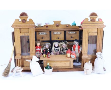 A miniature German grocery store room set, circa 1900, with glass windows to front and storage drawers to back wall with food