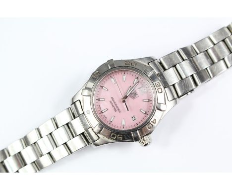 Lady's TAG Heuer Aquaracer wrist watch. The watch having a pink face with numeric and button dial, date aperture, rotating sp