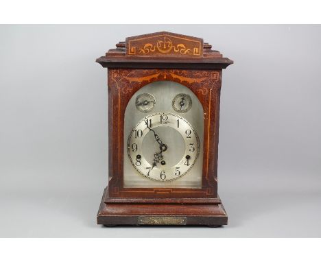 A mahogany cased bracket clock, silvered face with numeric dial, approx 19 x 40 x 28 cms, the clock having a brass German mov