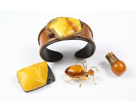 Unusual leather and amber bangle, together with a bug brooch and silver brooch.&nbsp;