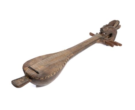 A LUTE (GAMBUS), NORTH SULAWESI, INDONESIA, MID-20TH CENTURY the bulbous wood body with hide face, tapering into the hollow n