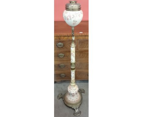 A late 19th Century brass and pottery standard oil lamp, the polygonal tapered reservoir, cylindrical stem and base painted w