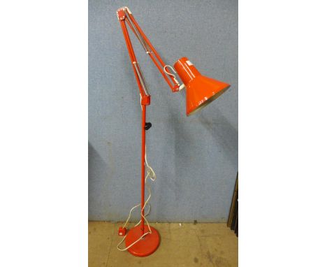 A red metal floor standing anglepoise lamp 