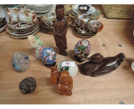 A selection of glass decorated eggs, carved treen figures including small carved Netsuke depicting mushroom with snail and fr