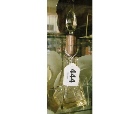 A glass scent bottle with silver rim
