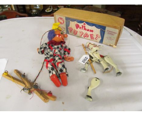 A Pelham puppet clown and a metal donkey puppet (leg detached)