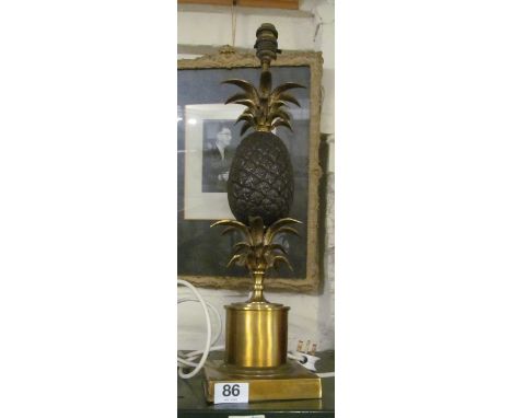 A brass table lamp with pineapple top