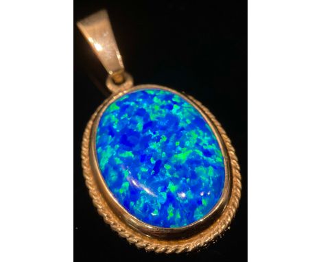 A deep blue stone oval pendant, possibly an opal, flashing vey vibrant blue green tones, 9ct gold mount, 2.2cm x 1,6cm, 3.5g 