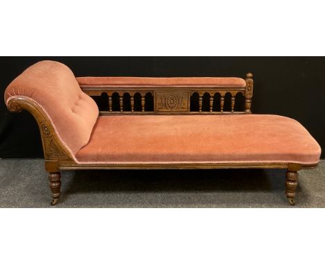 A Victorian oak scroll-end Chaise Longue, carved scroll, turned supports with ceramic casters, upholstered in pink velvet, 75