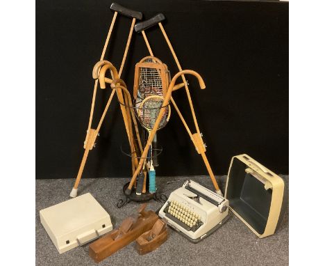 A wire work stick/umbrella stand;  walking sticks, pair of wooden crutches;  Tennis and Badminton racquets;  Vintage Adler Ga