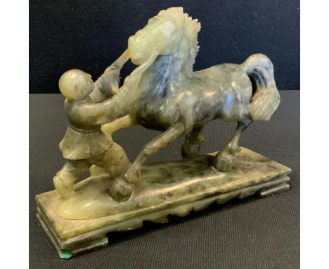 A Chinese jade coloured hardstone carving of a horse and figure, 19cm long 