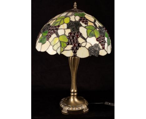 A Tiffany type table lamp, the shade of cream ground with grapes and vines in relief on a gilded base, 59cm high CONDITION RE