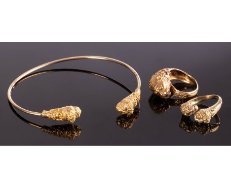 A 14k gold torc bangle with lion mask terminals, approximately 6.8g, a similar ring, apparently unmarked and a 14k gold ring 