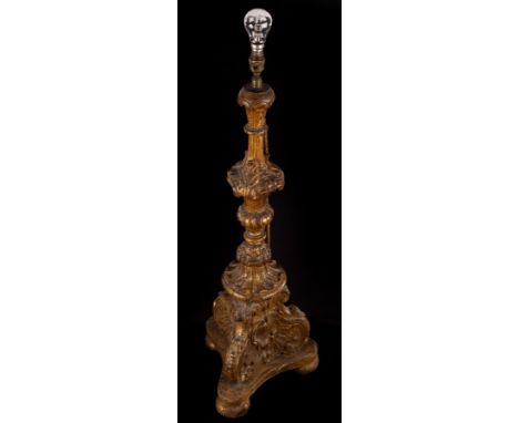 An Italian carved giltwood alter type candlestick on a tri-form base and bun feet, 86cm high, converted as a lamp CONDITION R