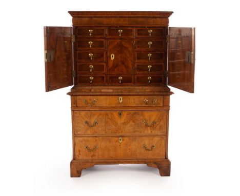 An 18th Century walnut and featherbanded cabinet on chest, (alterations), the cabinet with frieze drawer above arch inlaid pa