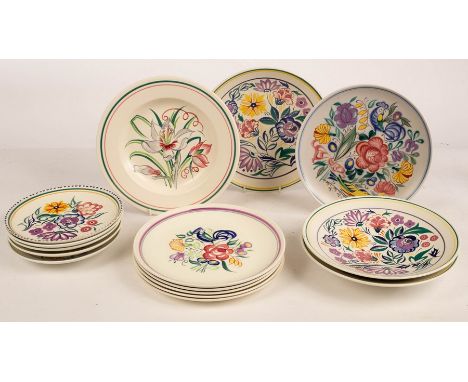 Poole Pottery, three floral shallow serving bowls, 26.5cm diameter, one signed N Blackmore, and four smaller, 20cm diameter, 
