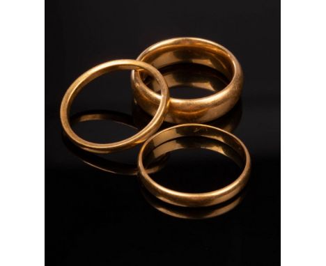 Two 22ct gold wedding bands, sizes K and N, approximately 12gm with a further yellow metal example, size N, approximately 2g 