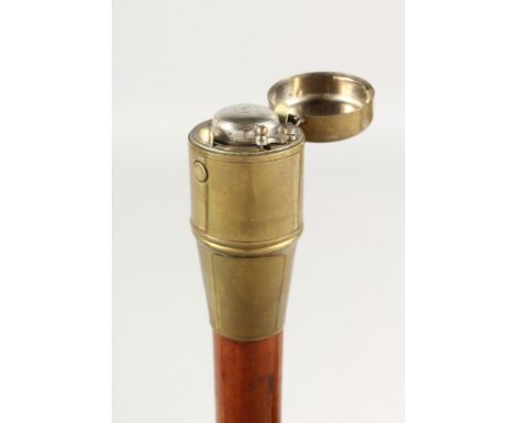 A 19TH CENTURY WALKING CANE with brass top opening to reveal an inkwell. 3ft long.