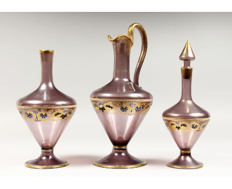 A VENETIAN AMETHYST TINTED GLASS EWER, with gilt and enamel decoration; together with the matching large and small decanter (