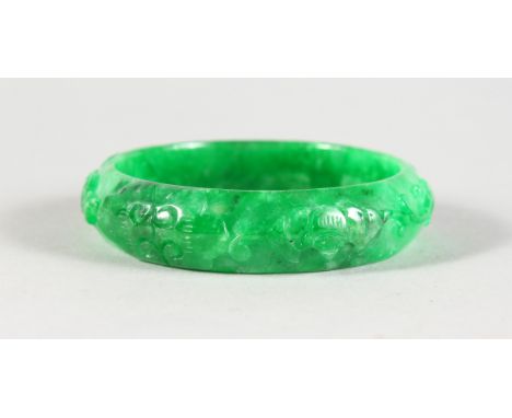 A CARVED CHINESE APPLE JADE BANGLE. 2.75ins diameter.