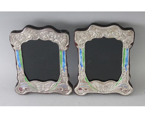 A PAIR OF NOUVEAU SILVER AND ENAMEL BUTTERFLY PHOTOGRAPH FRAMES. 8ins x 6.5ins.
