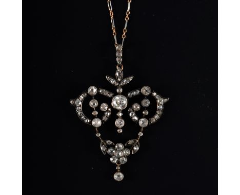 An Edwardian diamond pendant and chain, a central old brilliant cut diamond milgrain set within a yellow and white metal fram