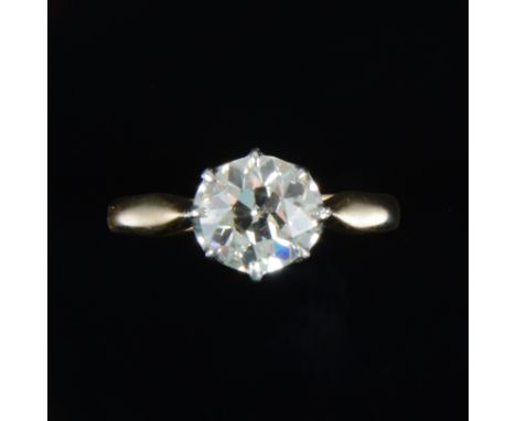 A diamond solitaire ring, the old brilliant cut stone claw set in a yellow and white metal single stone mount, shank marked 1