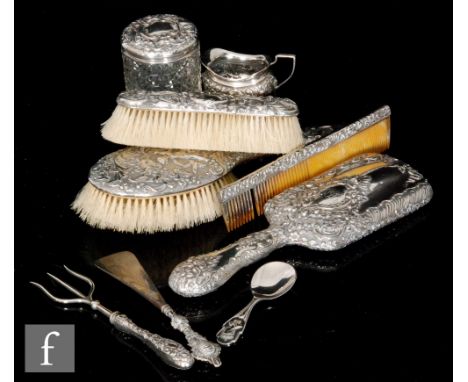 A composed hallmarked silver backed six piece dressing table set with a small cream jug and a toasting fork, S/D. (8) 